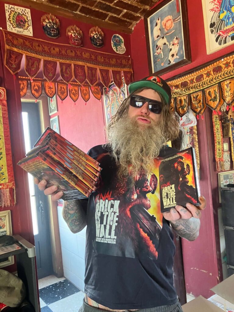Rob Ceus holding up stacks of Cement DVDs.