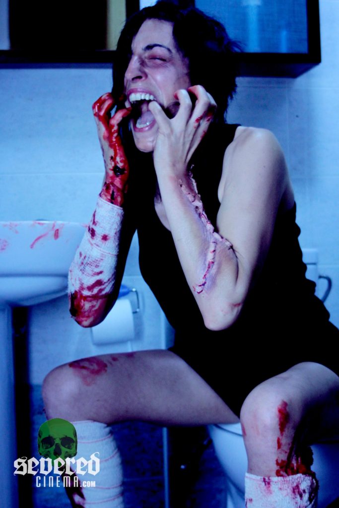 Screaming woman holding her face with a bloody arm