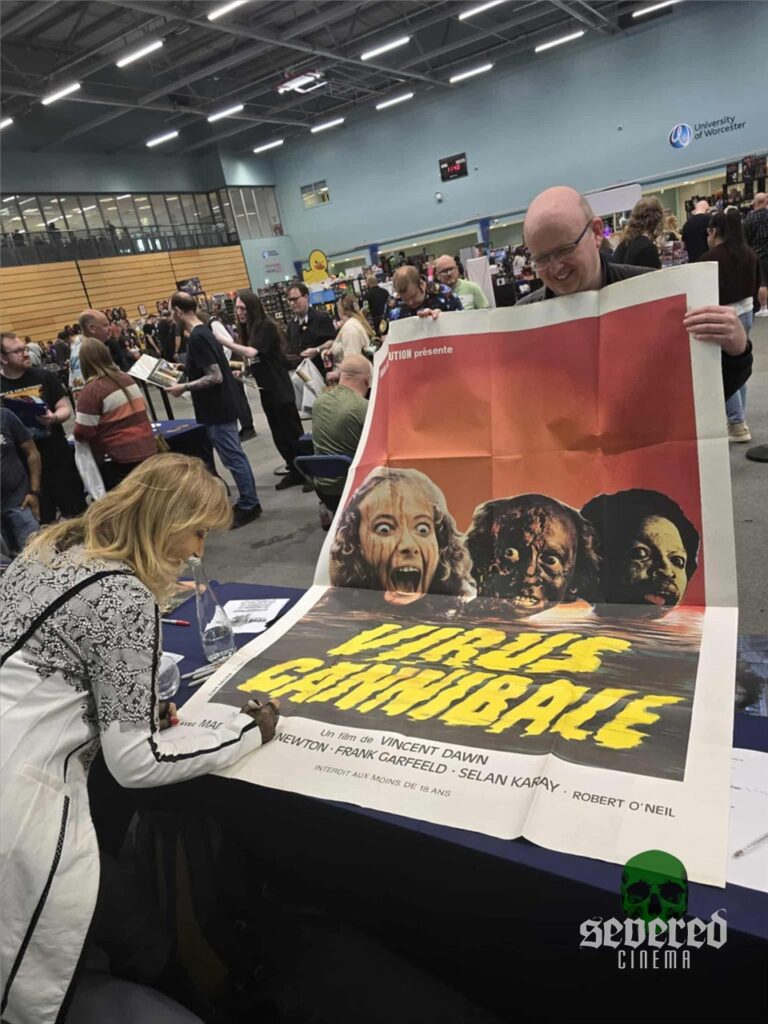 Photo of Margie Newton signing giant Virus poster at a convention