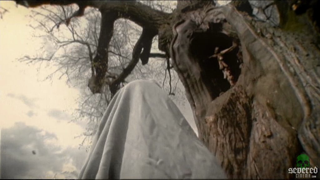 A white cloaked character in front an old tree in the movie Melancholie Der Engel